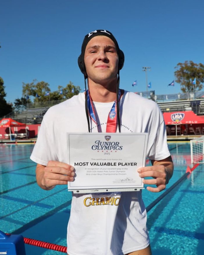 Gavin Conant holding the 18U Junior Olympics Most Valuable Player certificate on the pool deck